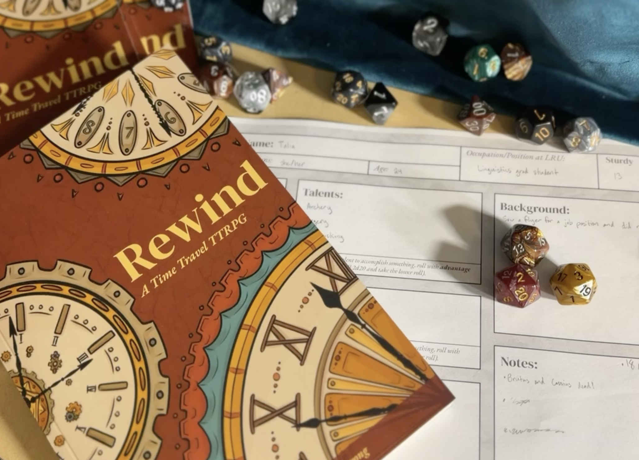 Printed Rewind rulebooks beside a filled-in character sheet and scattered polyhedral dice.