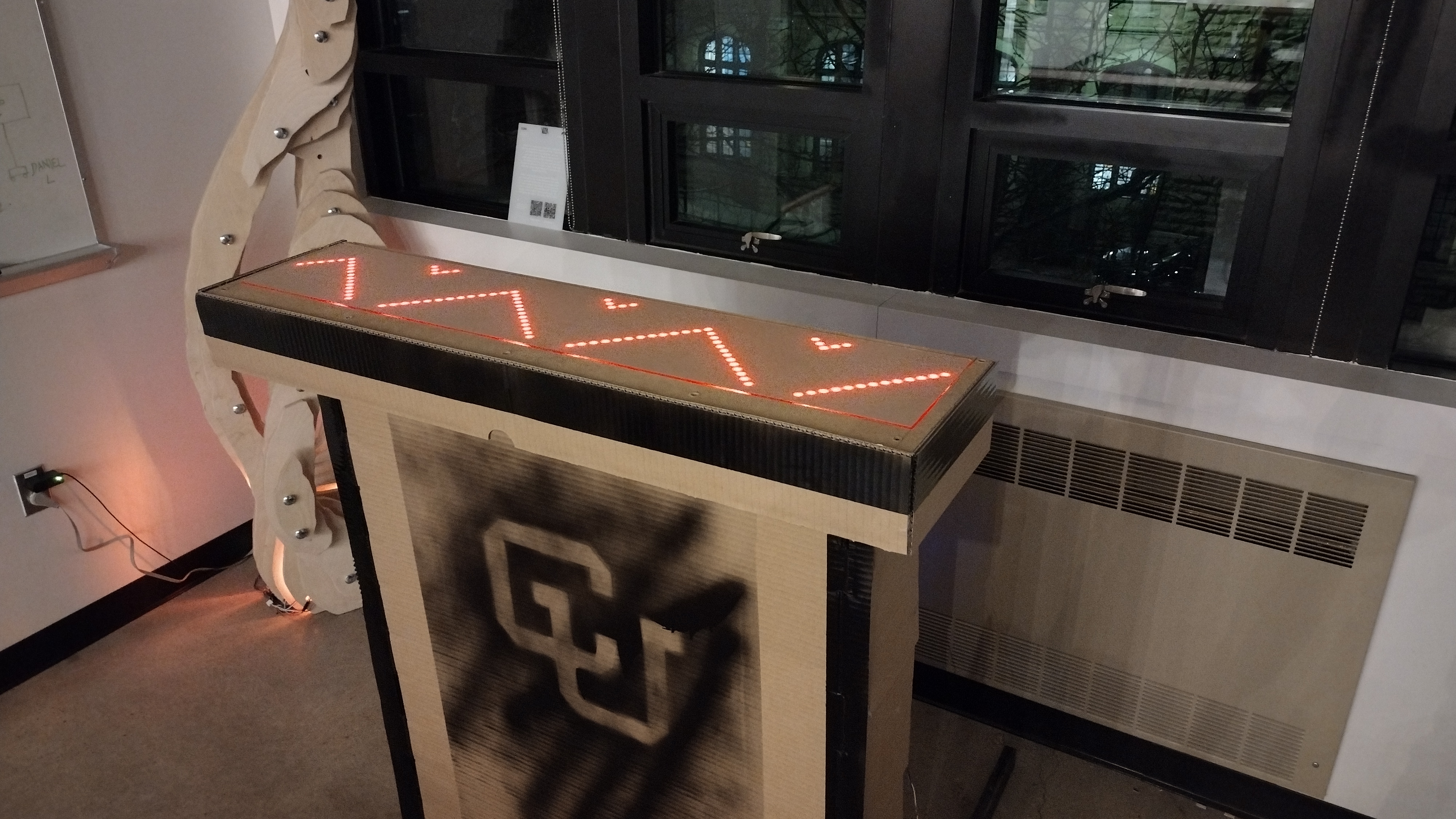 The bar top glowing with red zigzag LEDs above a CU logo panel.