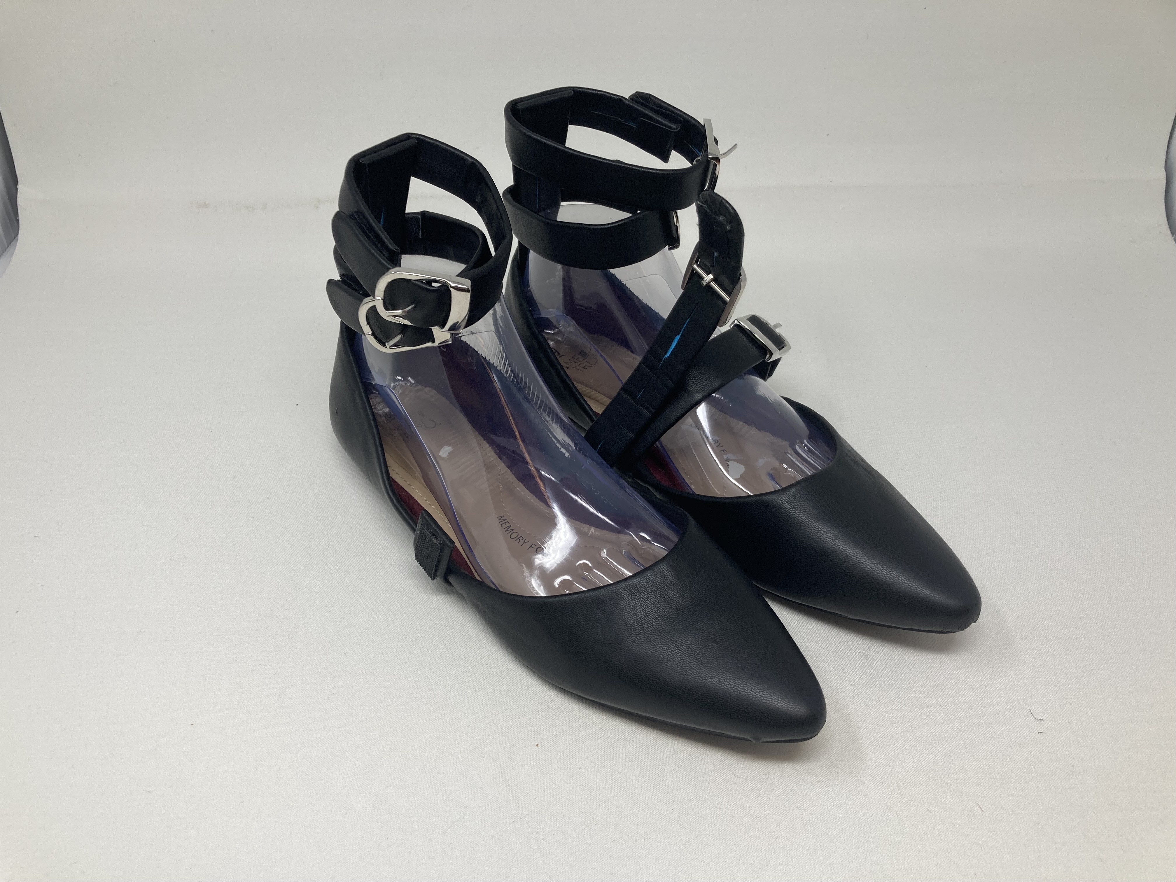 Pair of black ankle-strap pointed flats with silver buckles, on a white background.