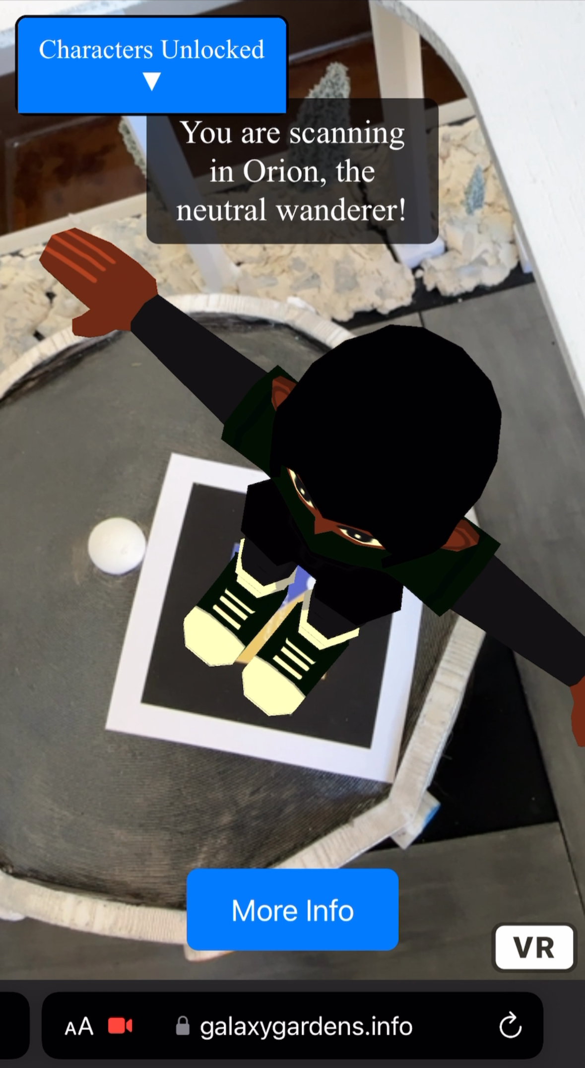 Phone AR view showing a 3D character, Orion the neutral wanderer, overlaid on the physical park model.
