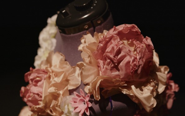 Close-up of clustered pink and cream fabric flowers covering the gown's bodice and neckline.